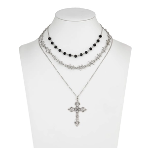 Detail of triple-layer punk necklace with black beads and ornate silver cross pendant