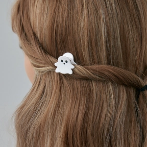 Gros plan d'une jolie pince à cheveux fantôme blanche portée sur de longs cheveux châtains