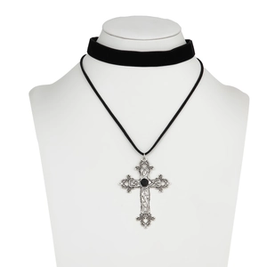 Macro view of silver hollow carved cross pendant with black bead on velvet choker