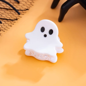 Détail d'une pince à cheveux fantôme blanc sur un fond festif orange pour Halloween