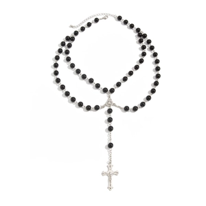 Macro detail of double-layer beaded necklace featuring a metallic crucifix pendant