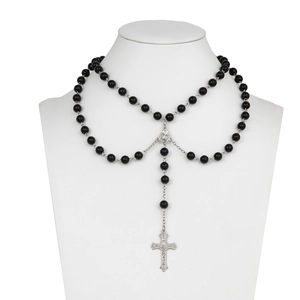Detail of dark punk beaded necklace with black round beads and silver cross pendant
