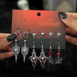 Dettaglio del set di 6 paia di orecchini Halloween con teschi, ragni e pendenti a croce
