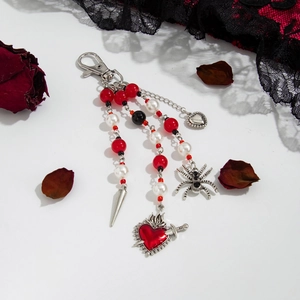 Gothic beaded keychain with cross, spider, heart pendants and red roses background