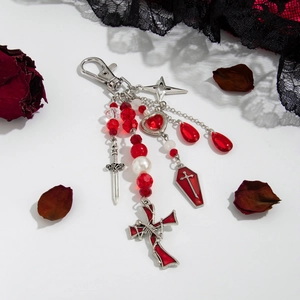 Gothic charm detail with red crystal beads, sword pendant, and heart coffin charm