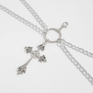 Detailed macro view of vintage gothic silver cross pendant with multilayered metal chains