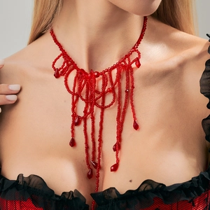 Detailopname van de rode kristallen kralenketting met gotische bloeddruppel franjes op model