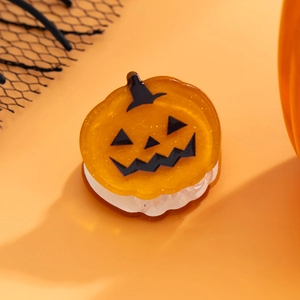 Vue macro d'une pince à cheveux citrouille orange pailletée pour Halloween