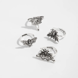 Detail of four retro silver gothic rings featuring moth and butterfly designs for women