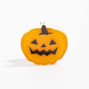 Gros plan sur la pince à cheveux citrouille orange avec visage Jack-o'-lantern d'Halloween