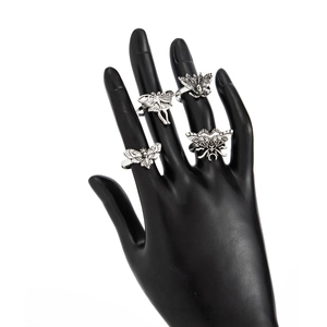 Macro shot of gothic moth and skull rings in vintage silver finish on black hand model