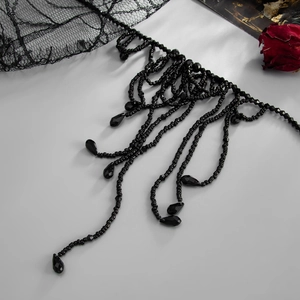 Gotische zwarte kralenketting met franjes en kristallen op een vintage achtergrond
