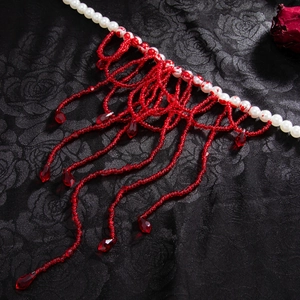 Detail van gotische Halloween-ketting met bebloede parels en rode kwastjes als druppels