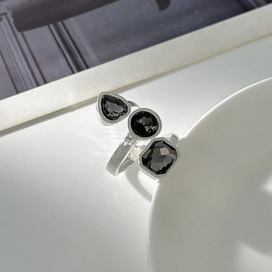Dettaglio anello in argento con pietre acriliche nere a cuore, tonde e taglio smeraldo