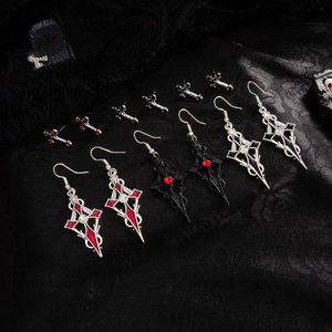 Set di orecchini a croce gotica con strass rossi su sfondo di pizzo nero