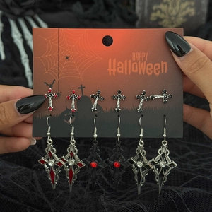 Dettaglio del set di orecchini gotici di Halloween con croci e teschi su cartoncino