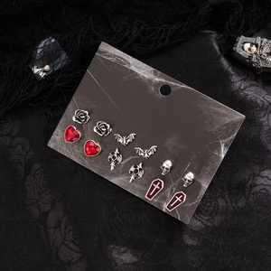 Gothic-Ohrring-Set mit Totenkopf, Fledermaus und Kreuz auf schwarzem Spitzenhintergrund