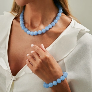 Nahaufnahme der böhmischen blauen Acrylperlenkette und des Armband-Sets auf Leinenhemd