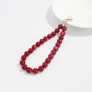 Macro shot of deep red marbled acrylic beads on a key chain with silver metal lobster clasp
