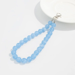 Detail of light blue beaded acrylic strap with metallic lobster clasp on a white plate