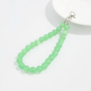 Detail view of light green translucent resin beads on a metal clasp for bags and keys