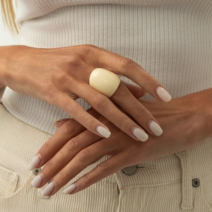 Close-up of a chunky cream resin ring worn on hand showing smooth texture and modern style