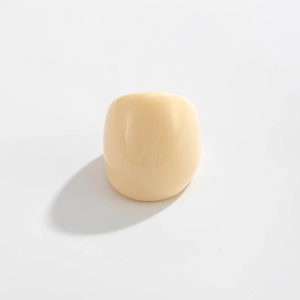 Detailed top view of a wide cream resin ring with a glossy smooth finish and soft shadows