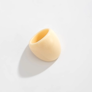 Macro shot of chunky cream resin ring with a polished surface and modern rounded shape