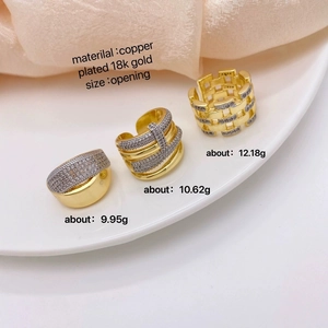 Detalle de anillos de cobre bañados en oro de 18k con circón sobre fondo de seda blanca