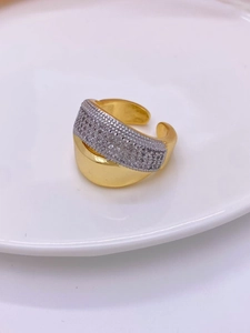 Detalle del anillo abierto bicolor con baño de oro a rayas y piedras de circonita pavé