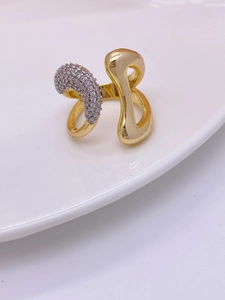 Close-up of 18K gold plated ring featuring asymmetric curves and pave-set zircons