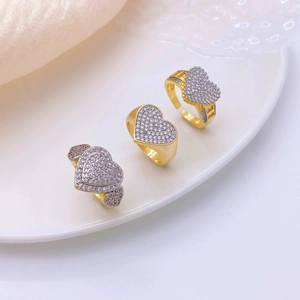 Vista dettagliata di tre anelli a cuore placcati oro 18k con pavé di zirconi scintillanti