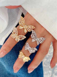 Close-up of butterfly zircon rings in gold and silver plating with shiny CZ stones