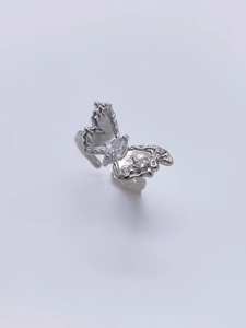 Macro detail of the silver butterfly ring with liquid metal texture and marquise zircon