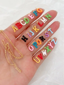 Macro shot of 26 colorful 18K gold-plated letter pendants with vibrant enamel finish