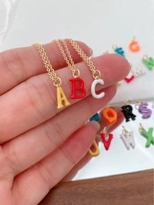 Detail of colorful enamel 18K gold plated uppercase initial letter pendant necklaces