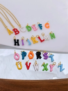 Macro detail of colorful 18K gold plated enamel letter pendants for DIY jewelry