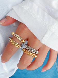 Detail von Gold- und Silber-Panzerkettenringen mit Punk-Nieten-Details an der Hand