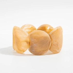 Macro detail of amber resin stretch bracelet showing marbled texture and curved links