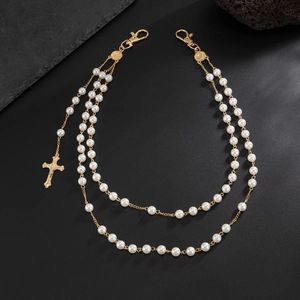 Detailed close-up of double-layer faux pearl waist chain with golden cross pendant