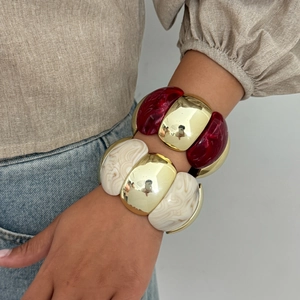 Detail of chunky resin bangles with gold metal inserts on model wrist