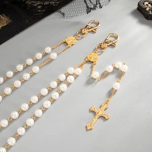 Detail view of cross pendant and imitation pearl beaded chain with religious emblem