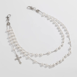 Detail of triple-layered pearl waist chain with cross pendant and metal clasps