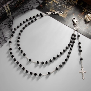 Detail of gothic multilayer waist chain with black beads and silver cross pendant