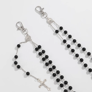 Detail of black bead chains with silver cross pendants and religious medallions