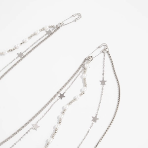 Detail of silver layered chain with star pendant and pearl beads for waist or pants