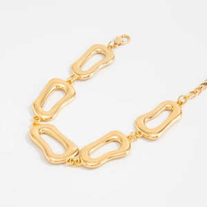 Makroaufnahme goldener geometrischer Glieder mit Karabinerverschluss an einer Kette