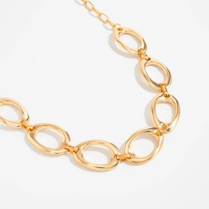 Detailaufnahme der goldenen geometrischen Kette mit unregelmäßig geformten Gliedern