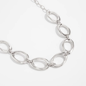 Makroaufnahme einer silbernen Gliederkette mit ovalen Ringen im minimalistischen Design