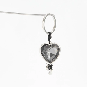 Detailed view of a dark heart acrylic gemstone pendant with silver metal accents and ring